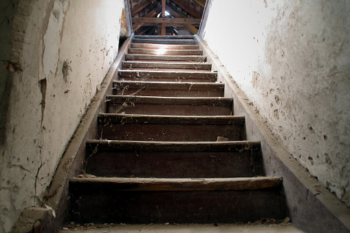 Old damaged wooden stairs to the garret. Entrance to the attic.