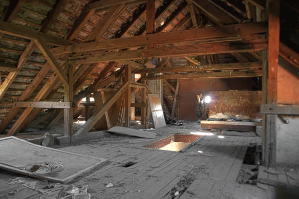 Old wooden roof beams on damaged garrett with wooden roof. The forgotten attic.