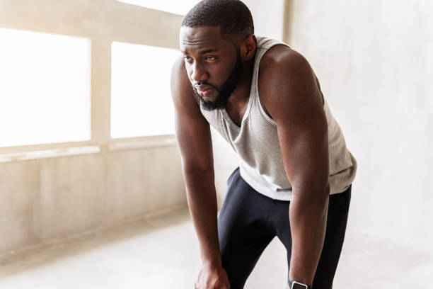 istock Exhausted african well-build man having break of exercise 690428622