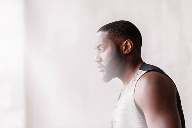 istock Pensive african attractive guy with beard standing by window 690429078