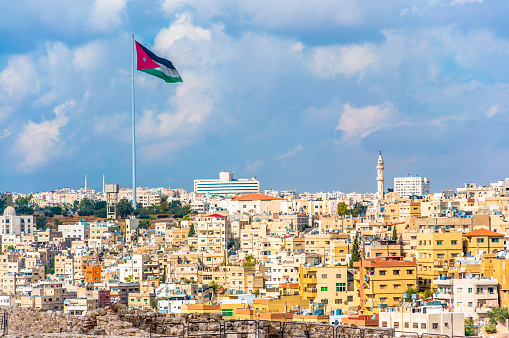 Amman houses and Jordan flag at sunny day