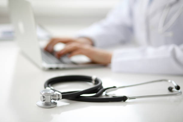 istock Female doctor typing on laptop, close up 690432966