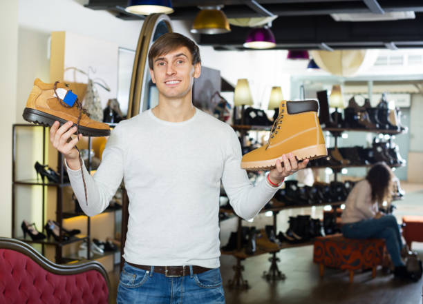 istock Man chooses shoes at shop 690436912