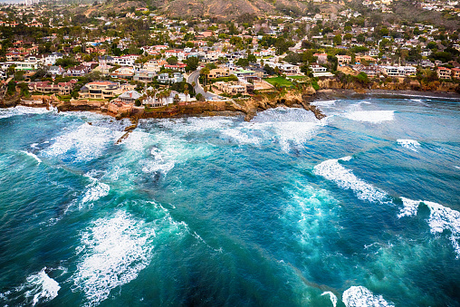 An aerial shot from over the Pacific Ocean of the residential area of La Jolla located within the city limits of San Diego, California.