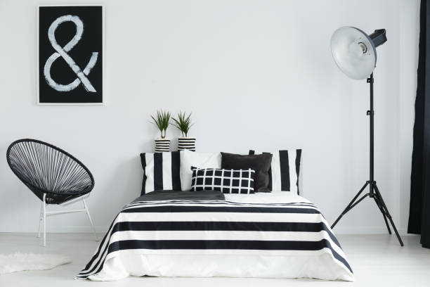 istock Bedroom with bed, lamp, and chair 690445092