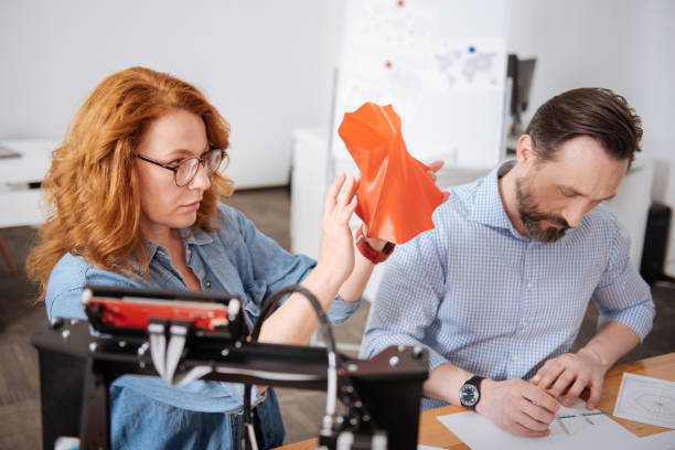 istock Serious beautiful woman holding a 3d printed object 690452838