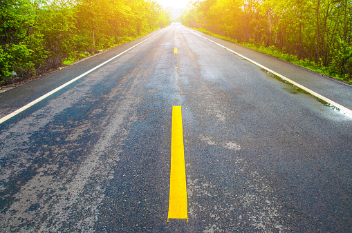 Close up road view of yellow center lines with white sky background