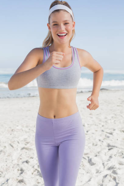 istock Sporty blonde jogging on the beach 690473290