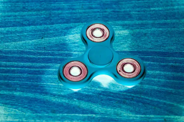Photo of Fidget Spinner in fluorescent UV glowing isolated background