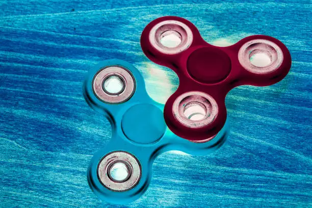 Photo of Fidget Spinner in fluorescent UV glowing isolated background