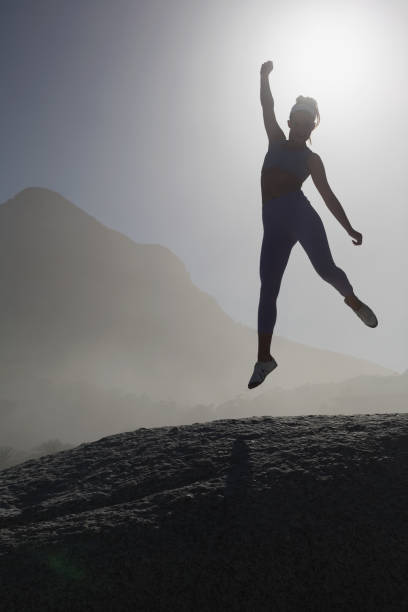 istock Sporty blonde on the beach on a rock jumping 690474000