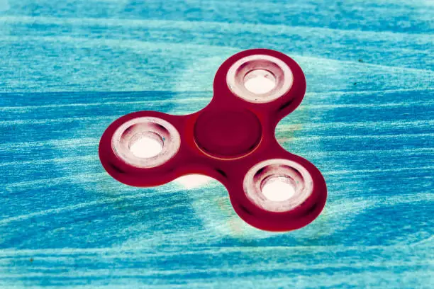 Photo of Fidget Spinner in fluorescent UV glowing isolated background