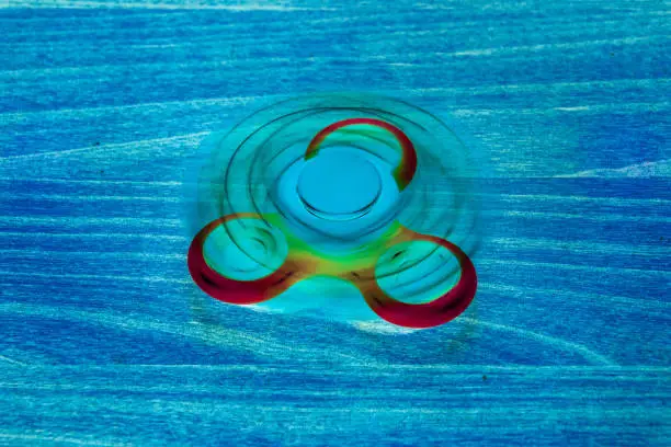 Photo of Fidget Spinner in fluorescent UV glowing isolated background