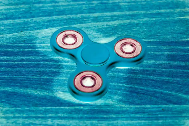 Photo of Fidget Spinner in fluorescent UV glowing isolated background