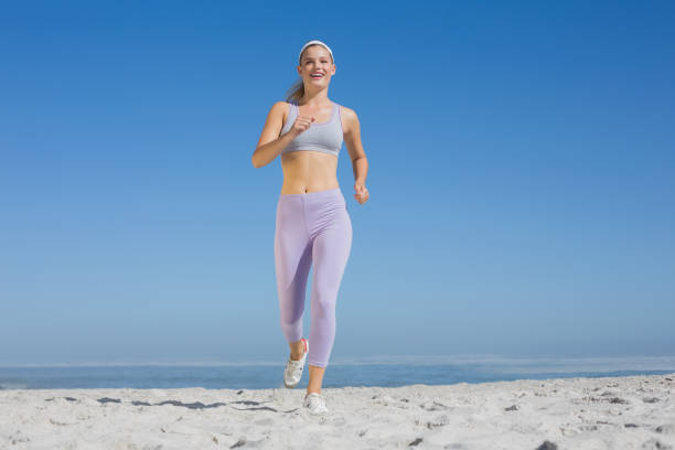 jogging in th beach - woman runns near sea on early summer morning