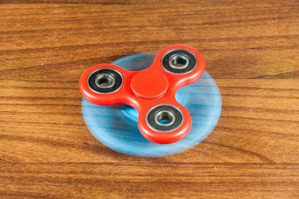 Photo of Spinner toy in wooden isolated background