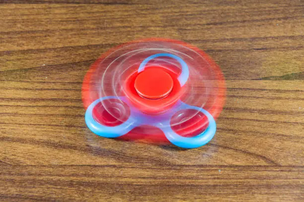 Photo of Spinner toy in wooden isolated background