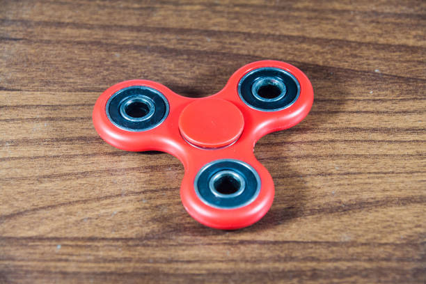 istock Spinner toy in wooden isolated background 690477828