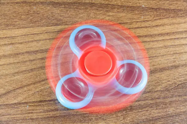 Photo of Spinner toy in wooden isolated background