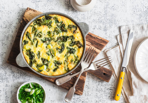 kartoffel und spinat tortilla in einer pfanne auf einem hellen hintergrund. leckere vorspeise oder snack, ansicht von oben - quiche stock-fotos und bilder