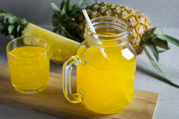 istock Pineapple juice in a jar on stone table. 690493532