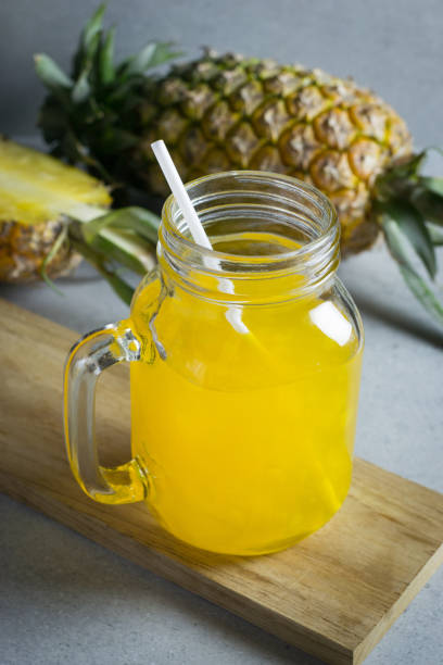 istock Pineapple juice in a jar on stone table. 690493600