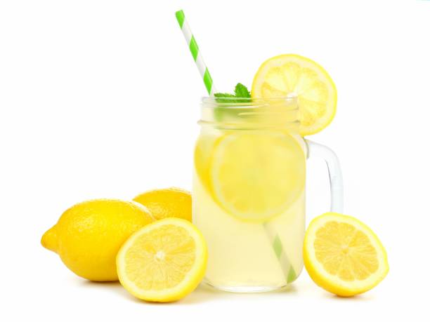 istock Mason jar of lemonade with lemons and straw over white 690507430