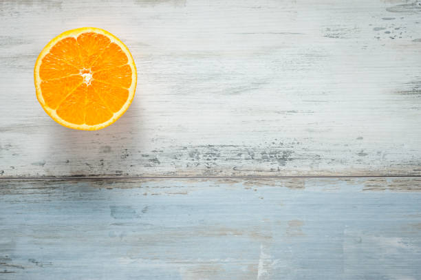 One slice of fresh oranges on painted wooden board