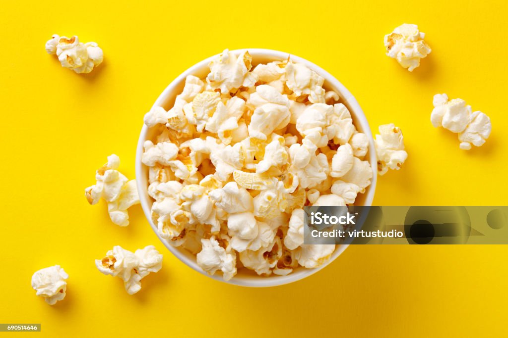 Popcorn viewed from above on yellow background. Flat lay of pop corn bowl. Top view Popcorn Stock Photo