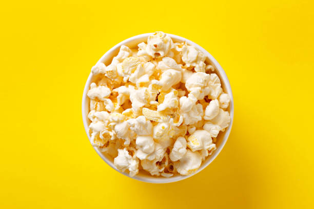 istock Popcorn bowl viewed from above on yellow background. Flat lay. Top view 690514690