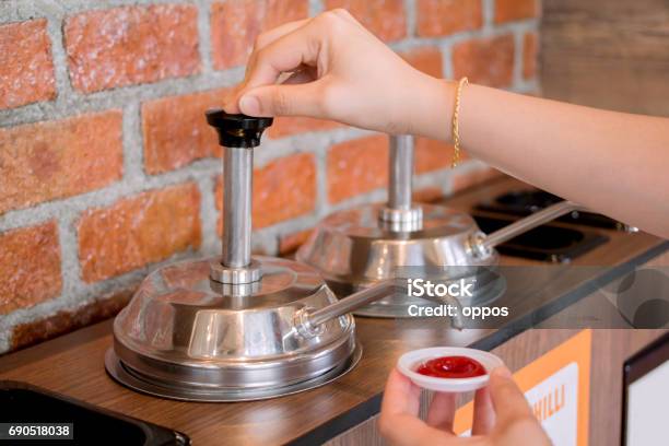 Womans Hand Pumping The Ketchup Stock Photo - Download Image Now - Condiment, Ketchup, Restaurant