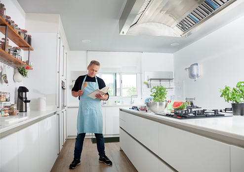 Man cooking, posing proud. Modern kitchen