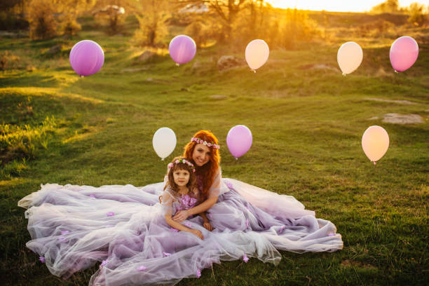 junge rothaarige mutter mit ihrer tochter auf die natur in der sonne ausruhen - sun sky child balloon stock-fotos und bilder