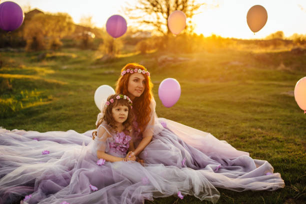 junge rothaarige mutter mit ihrer tochter auf die natur in der sonne ausruhen - sun sky child balloon stock-fotos und bilder