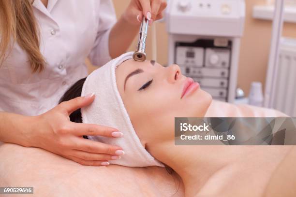 The Doctorcosmetologist Makes The Procedure Microdermabrasion Of The Facial Skin Of A Beautiful Young Woman Stock Photo - Download Image Now