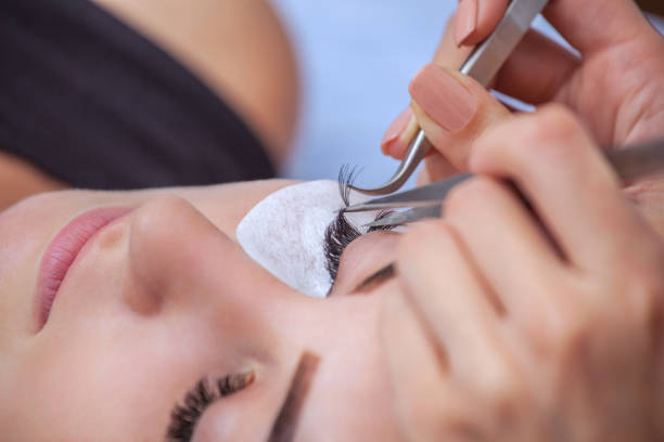 Makeup Master corrects, and strengthens eyelashes beams, holding out a pair of tweezers in a beauty salon. Makeup Master corrects, and strengthens eyelashes beams, holding out a pair of tweezers in a beauty salon. Professional care for the skin and eyes. sable stock pictures, royalty-free photos & images