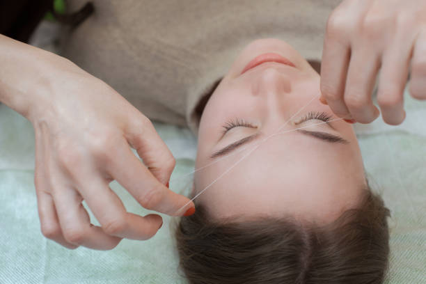 istock Master corrects makeup gives shape and thread plucks eyebrows in a beauty salon. 690532094