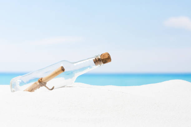 istock Message in bottle on beach with white sand,  in tropical sea 690541764