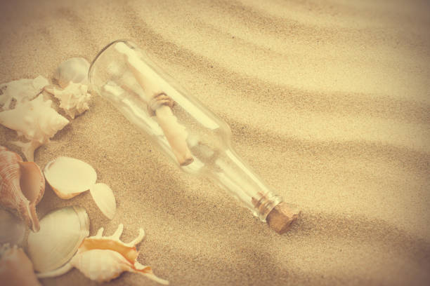 istock Message in bottle on the beach. Summer background with hot sand 690541794