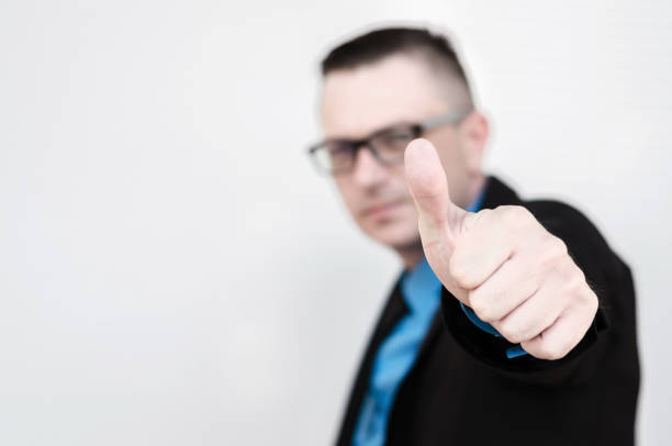 istock man shows ok sign with thumb in front of the wall with space for text 690542732