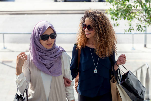 istock two beautiful girls with shopping bags 690551178