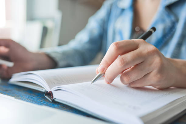 istock Person writing notes and working on the phone 690551644