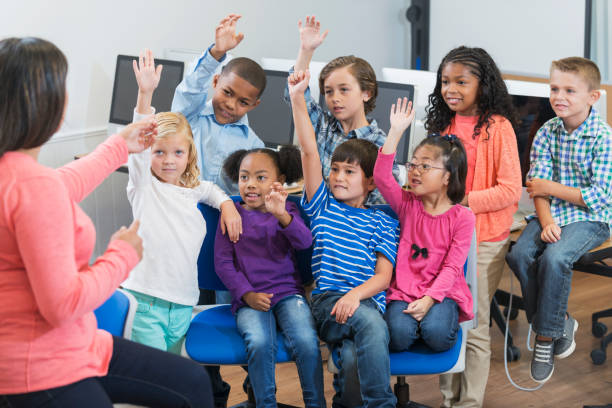 istock Multi-ethnic group of school children raising hands 690552190