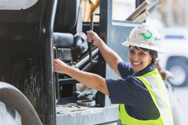 istock Hispanic woman worker climbing onto forklift 690552792