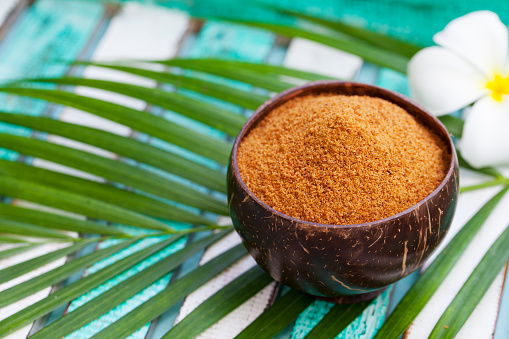 Coconut brown sugar in a wooden bowl. Tropical background