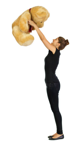 istock Joyful Russian model holding up large yellow teddy bear 690557800