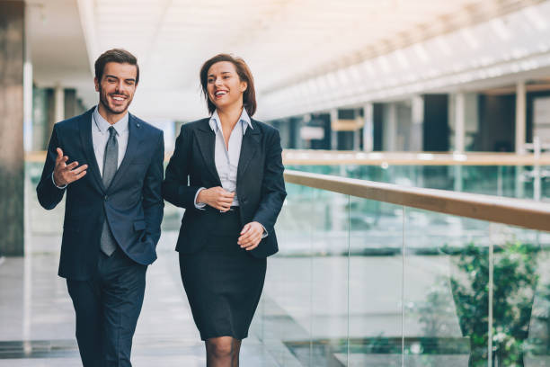 Business relationships Couple of business persons walking and talking well dressed stock pictures, royalty-free photos & images