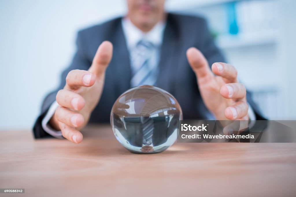 Businessman forecasting a crystal ball Businessman forecasting a crystal ball in the office 40-49 Years Stock Photo