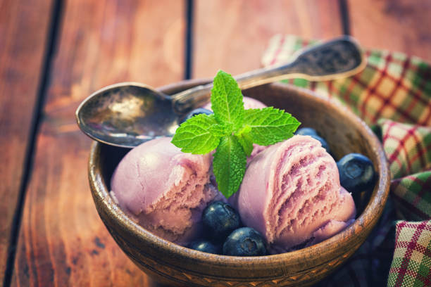 Homemade blueberry ice cream with mint served in bowl on the old wooden background