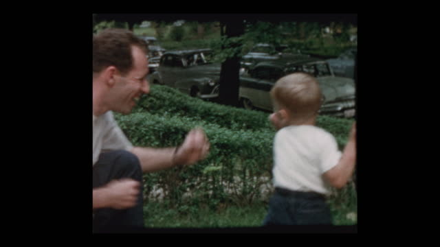 50's dad and young son play fighting, box and rough house